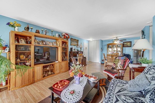 living area with wood finished floors and ceiling fan