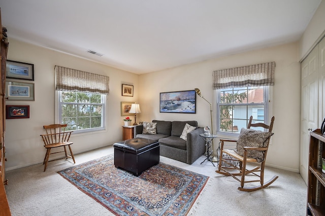 carpeted living area featuring visible vents and a healthy amount of sunlight
