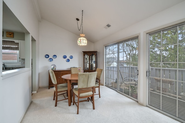 dining area with lofted ceiling, light carpet, and plenty of natural light