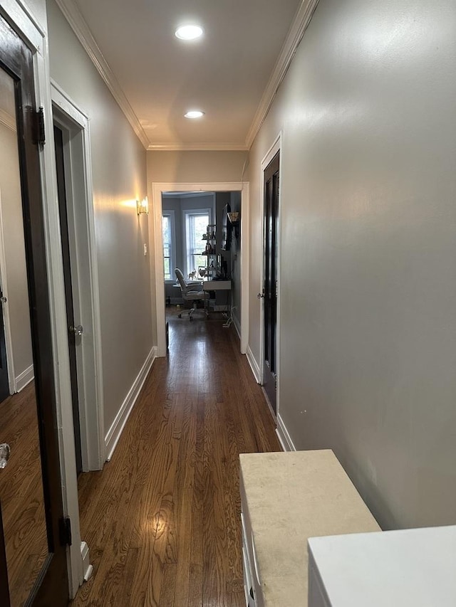 hallway featuring crown molding, baseboards, recessed lighting, and dark wood-type flooring