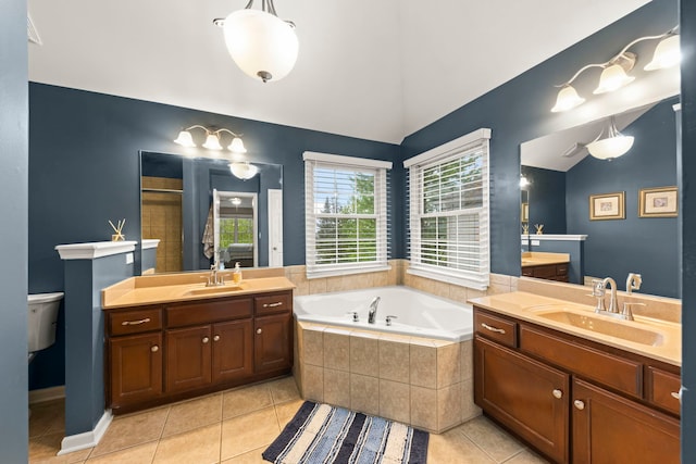 bathroom featuring vaulted ceiling, tile patterned flooring, two vanities, a bath, and toilet