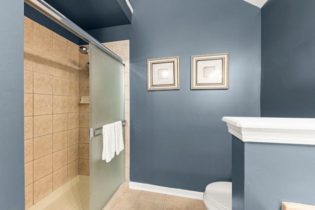 full bathroom featuring a stall shower, tile patterned flooring, toilet, and baseboards