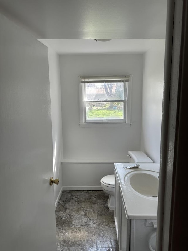 1716 Rogers Ave, Mchenry, IL 60050 - half bathroom featuring toilet, baseboards, vanity, and stone finish floors