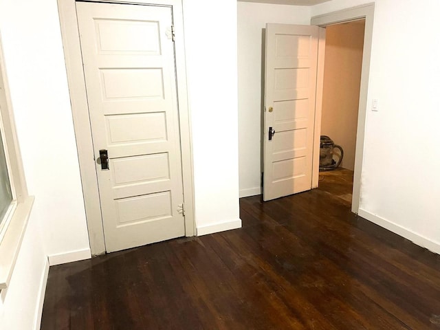 interior space with baseboards and dark wood-type flooring
