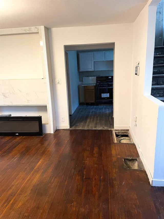 corridor with hardwood / wood-style flooring and baseboards