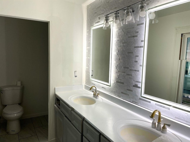 bathroom featuring a sink, double vanity, and toilet