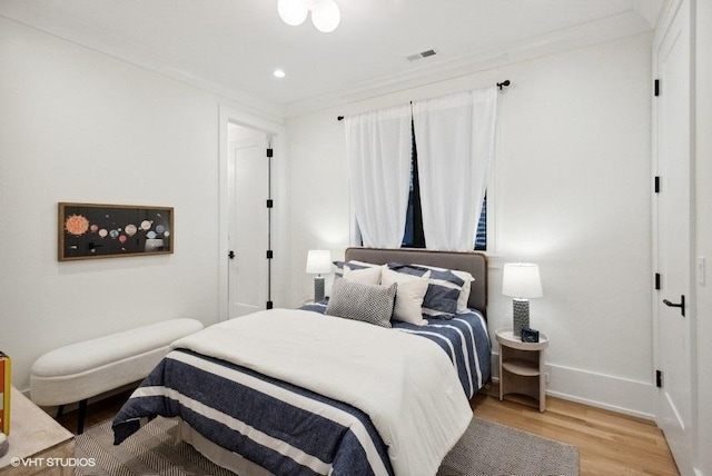 bedroom with light wood-style floors, baseboards, ornamental molding, visible vents, and recessed lighting