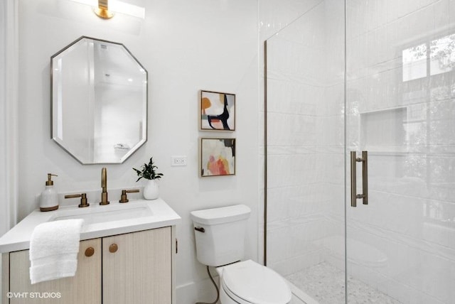 bathroom featuring toilet, vanity, and a stall shower