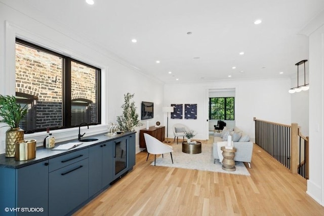 living area with recessed lighting, crown molding, and light wood-style flooring