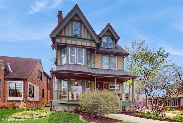 victorian house featuring a chimney and a porch