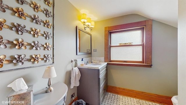 bathroom featuring lofted ceiling and vanity