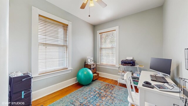 office area with baseboards, wood finished floors, and a ceiling fan