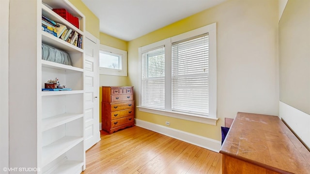 office area featuring built in shelves, hardwood / wood-style floors, and baseboards