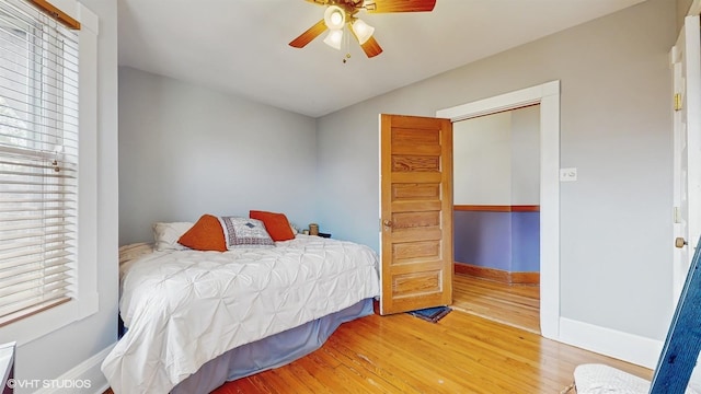 bedroom with lofted ceiling, wood finished floors, a ceiling fan, and baseboards