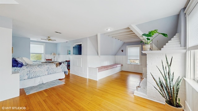 bedroom with light wood finished floors, a ceiling fan, visible vents, and vaulted ceiling