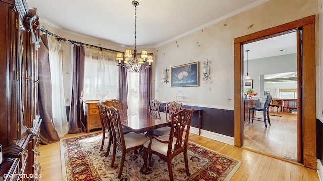 dining area featuring ornamental molding, an inviting chandelier, and light wood-type flooring