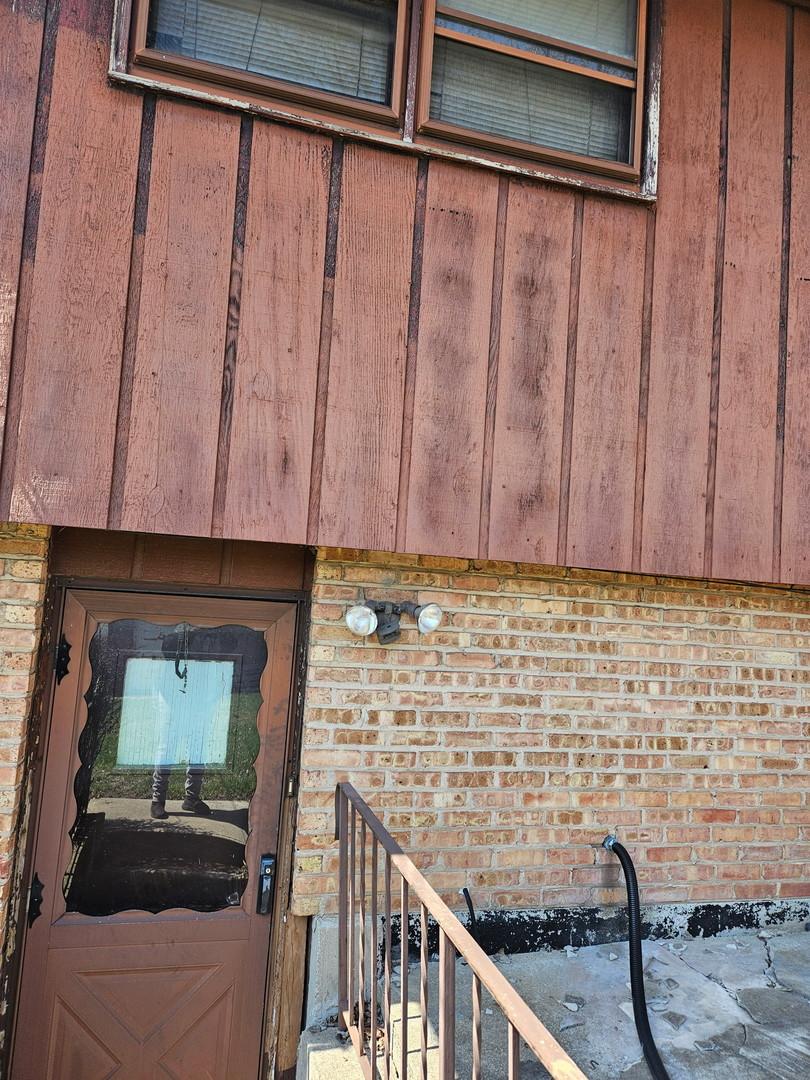 property entrance with brick siding and board and batten siding