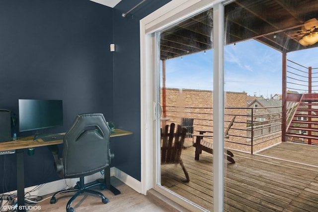 office space with a wealth of natural light, wood finished floors, and baseboards