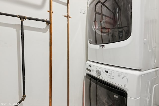 clothes washing area with stacked washer and clothes dryer