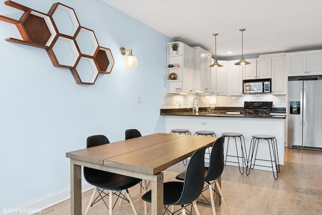 dining space with recessed lighting and light wood-style floors