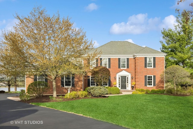 view of front of property with brick siding and a front yard