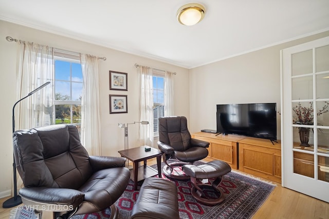 living room featuring ornamental molding and light wood-style flooring