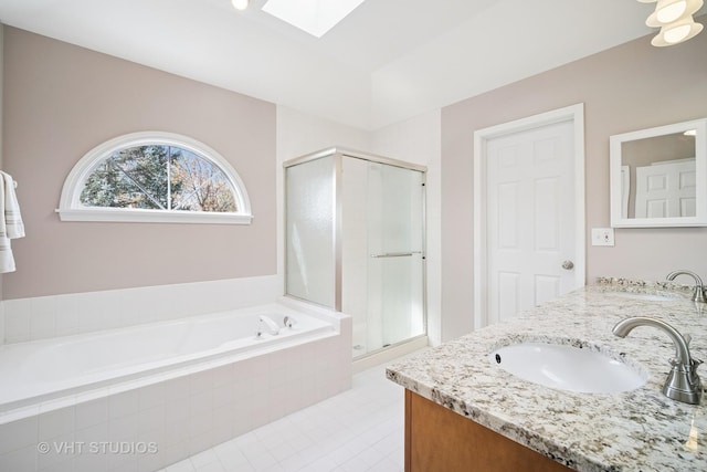 full bathroom with a skylight, a shower stall, a sink, and a bath