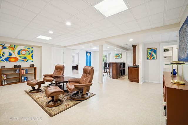 sitting room featuring baseboards, recessed lighting, and indoor bar