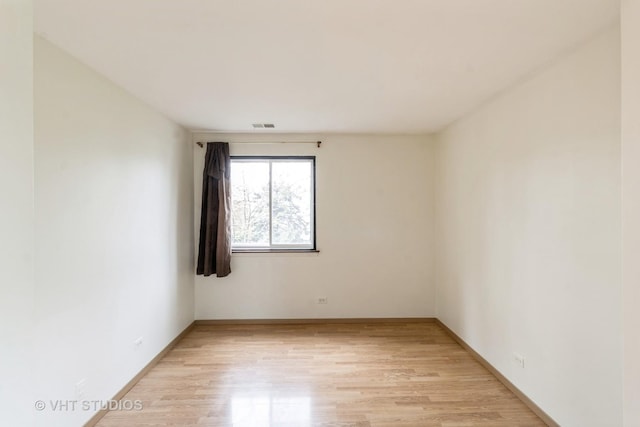 unfurnished room with baseboards, visible vents, and light wood-type flooring