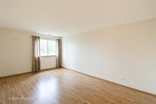 empty room featuring baseboards and light wood-style floors