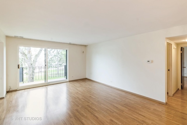 empty room featuring light wood-style flooring, baseboards, and visible vents