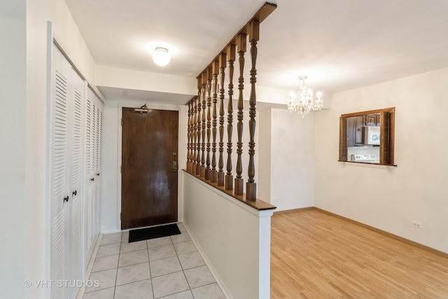 interior space with baseboards, light wood finished floors, and a chandelier