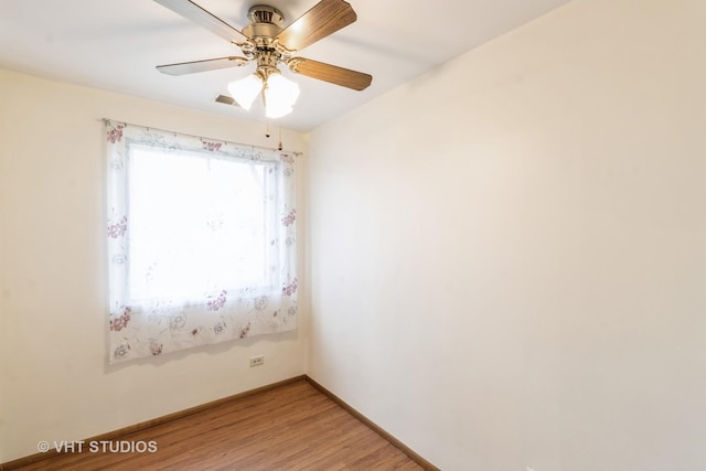 spare room featuring ceiling fan, baseboards, and light wood-style floors