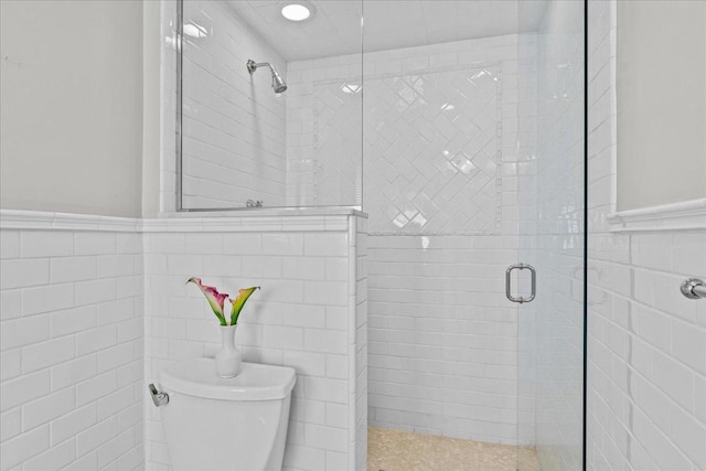 2341 Lincolnwood Dr, Evanston, IL 60201 - bathroom with a shower stall, toilet, a wainscoted wall, and tile walls