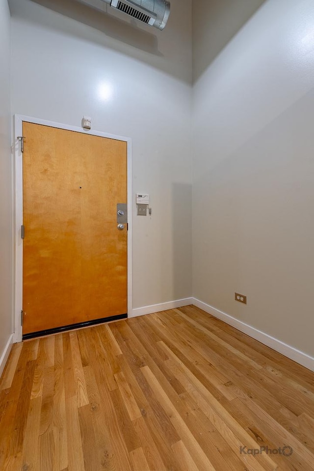 doorway to outside featuring light wood-type flooring, visible vents, and baseboards