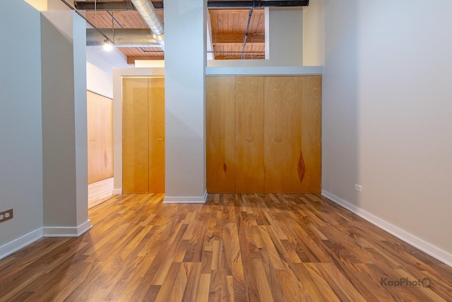 spare room featuring baseboards and wood finished floors