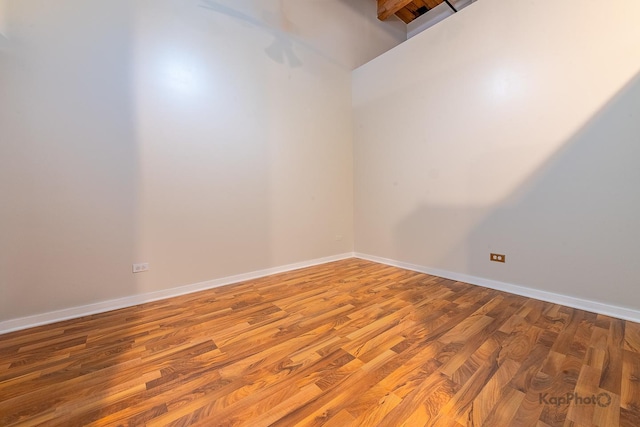 unfurnished room with baseboards and wood finished floors