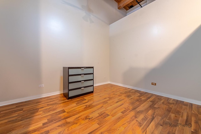 unfurnished room featuring baseboards and wood finished floors