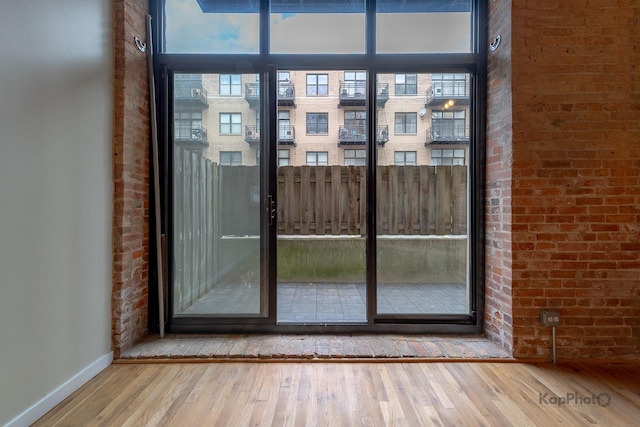 doorway to outside with wood finished floors and baseboards
