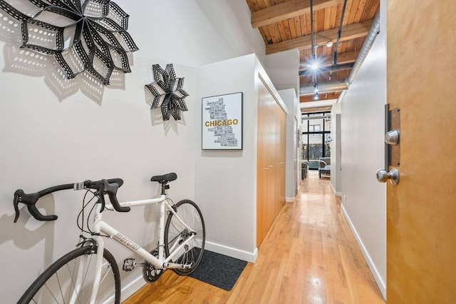 corridor featuring wood ceiling, baseboards, beam ceiling, and wood finished floors
