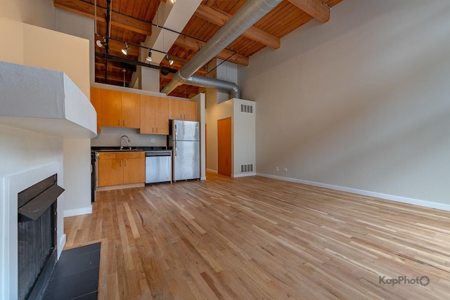kitchen with dark countertops, visible vents, appliances with stainless steel finishes, and a high ceiling