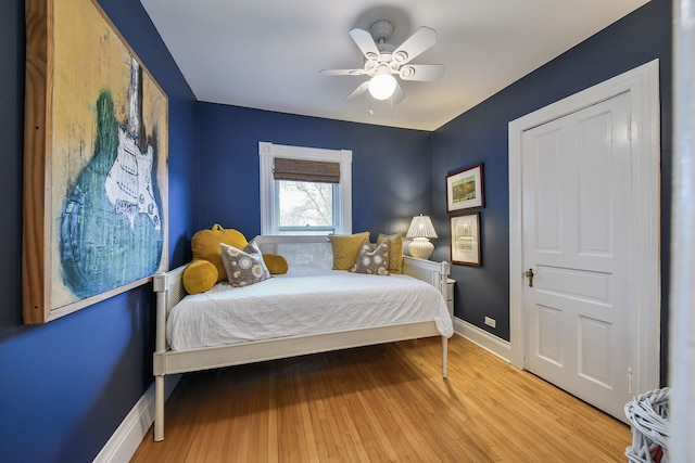 bedroom with baseboards, ceiling fan, and hardwood / wood-style flooring