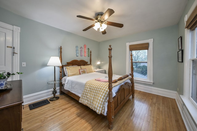 bedroom featuring a ceiling fan, baseboards, visible vents, and light wood-style flooring