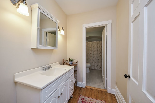full bathroom featuring vanity, baseboards, toilet, and wood finished floors