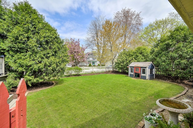 view of yard featuring an outdoor structure and fence
