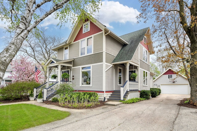 victorian house featuring an outbuilding, roof with shingles, and a garage