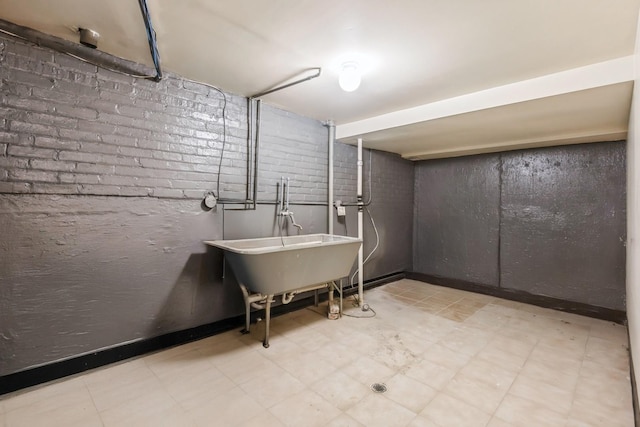 7010 S E End Ave Unit 4, Chicago, IL 60649 - finished basement featuring tile patterned floors, brick wall, and a sink