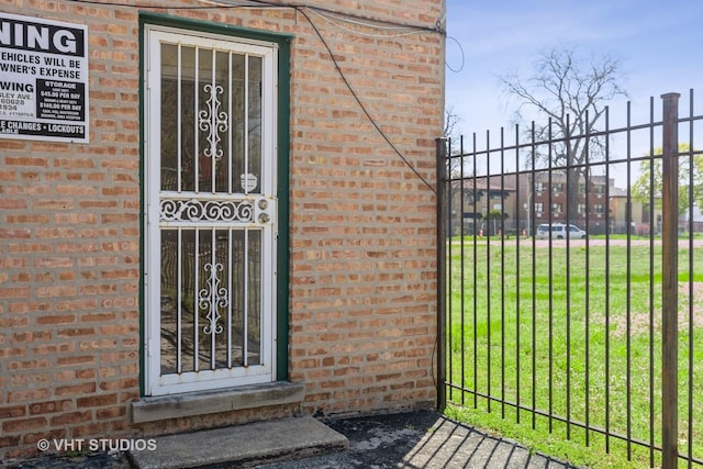 7010 S E End Ave Unit 4, Chicago, IL 60649 - doorway to property featuring fence, a lawn, and brick siding