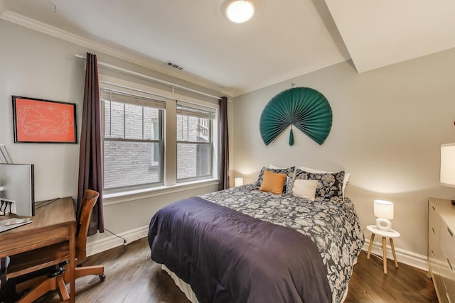 bedroom with baseboards, visible vents, ornamental molding, and wood finished floors
