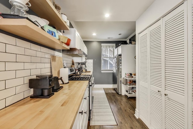 kitchen with wooden counters, dark wood-style flooring, open shelves, stainless steel appliances, and white cabinetry